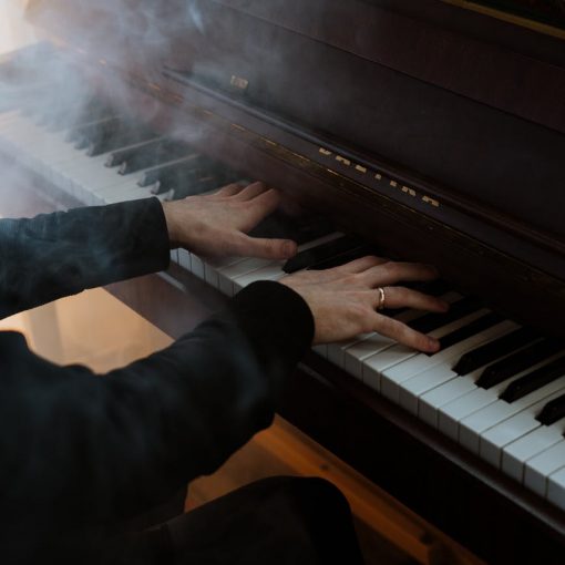 person in black pants playing piano